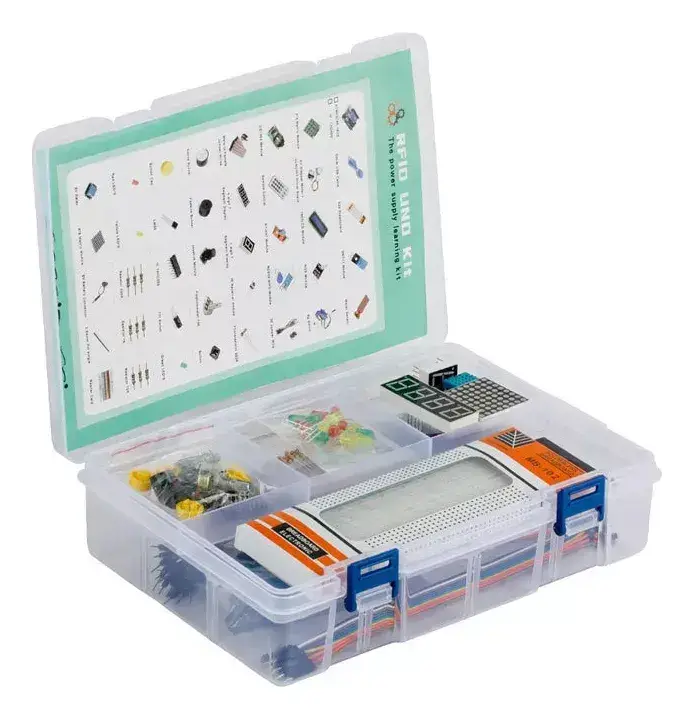 Caja organizadora transparente abierta, con la protoboard y los componentes en sus compartimentos