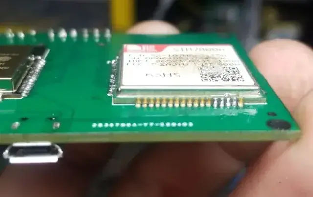 Primer plano del módem celular soldado directamente sobre la PCB a la medida.